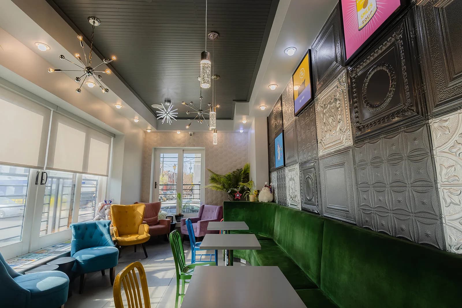 The cafe's long green velvet banquette running beside a pressed-tin wall
