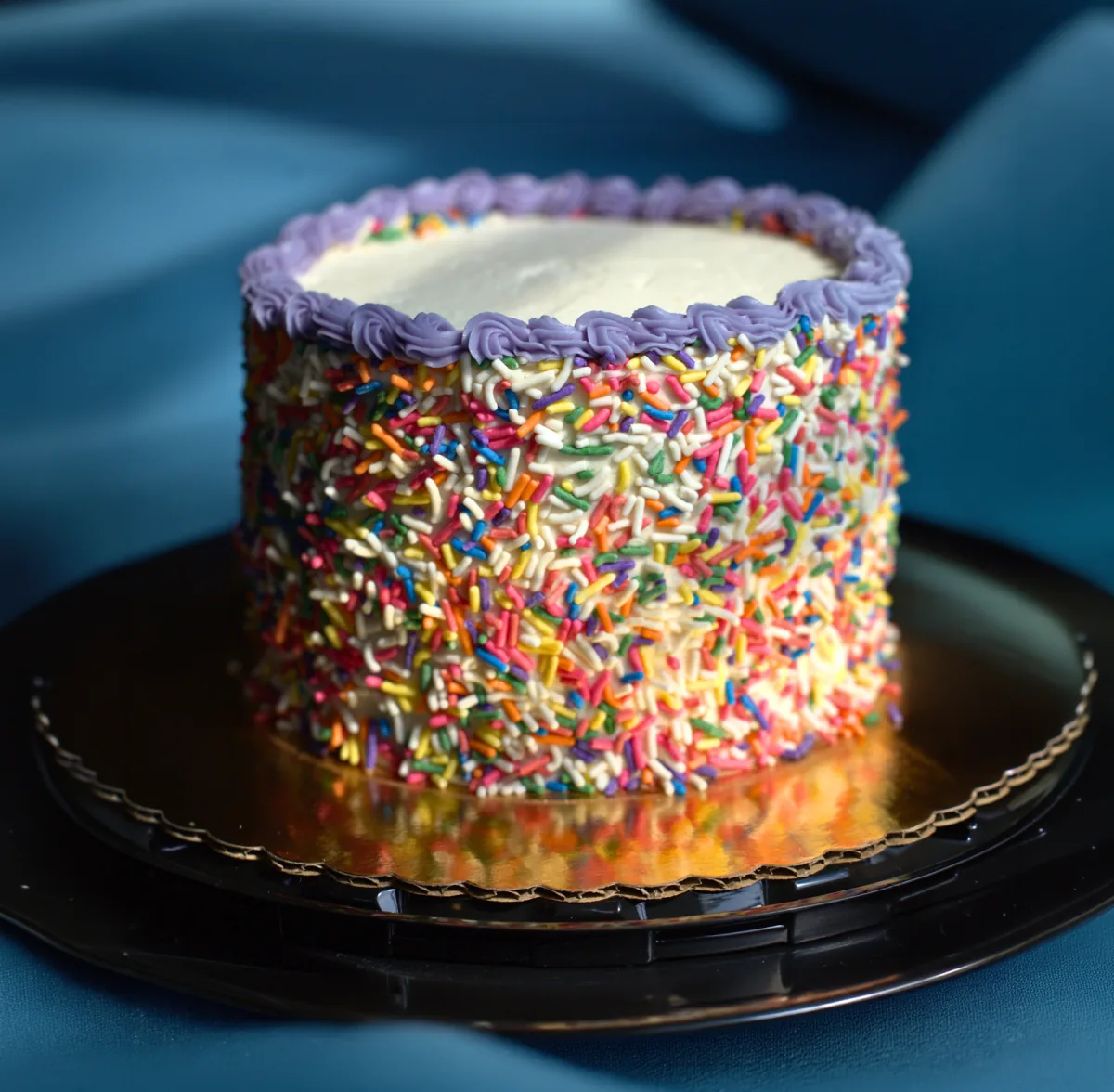 Vegan birthday cake covered in rainbow sprinkles from Batter & Crumbs